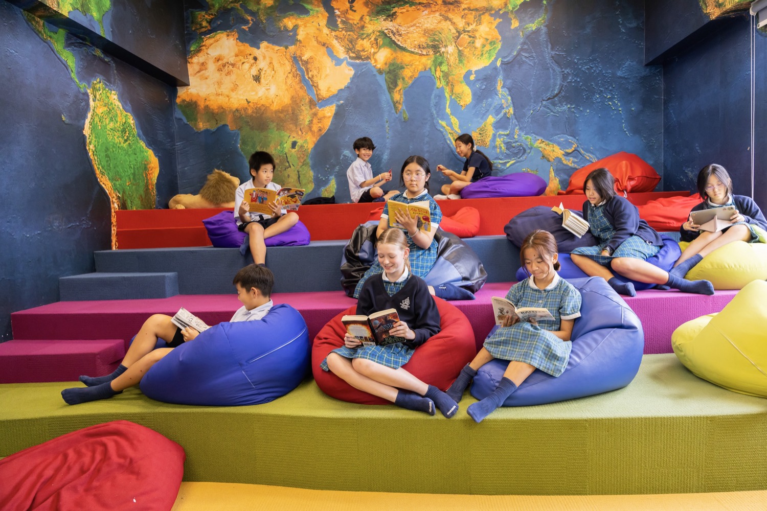 世界地図の前で読書するマルボロの生徒たち